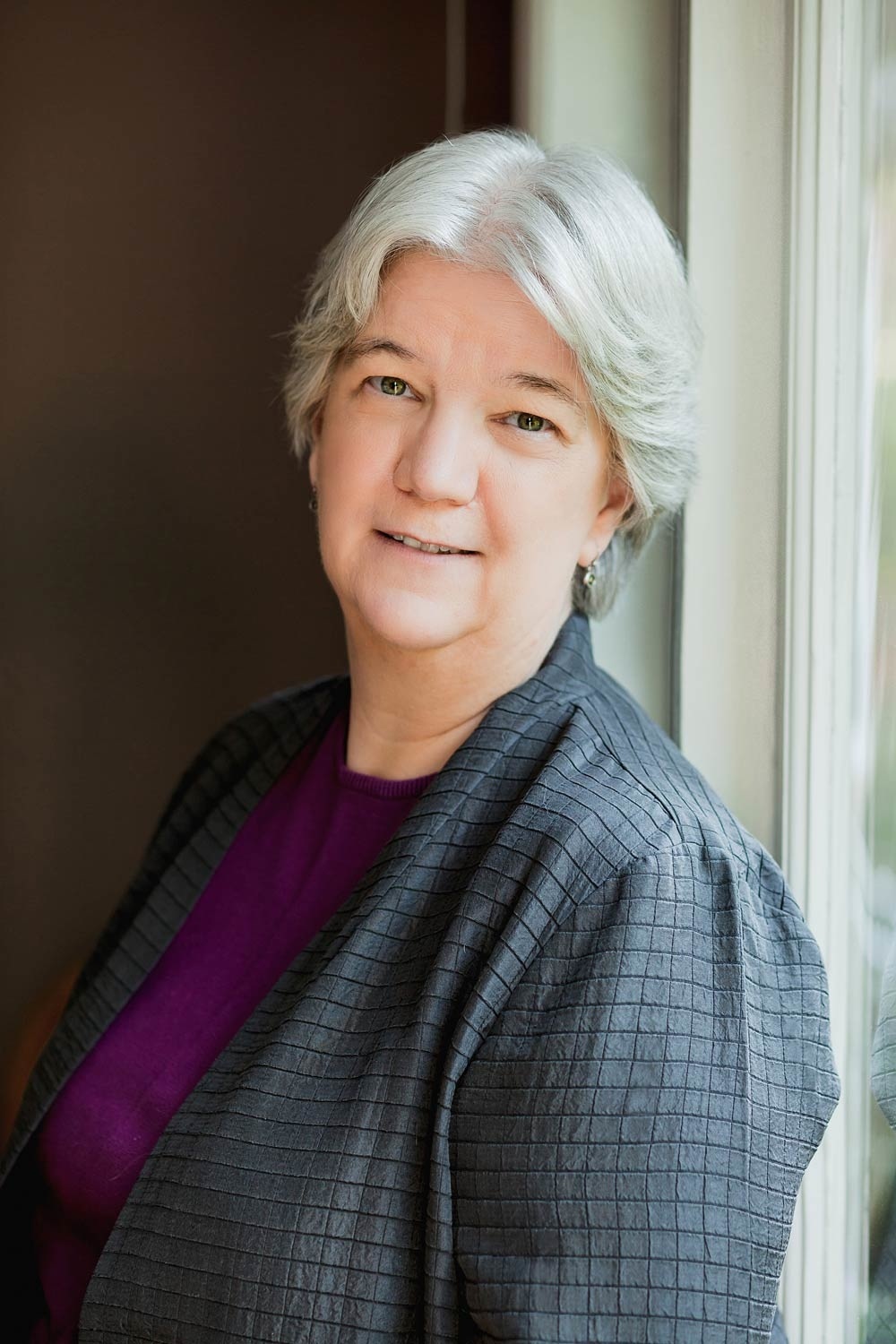 Woman in headshot wearing a gray blazer